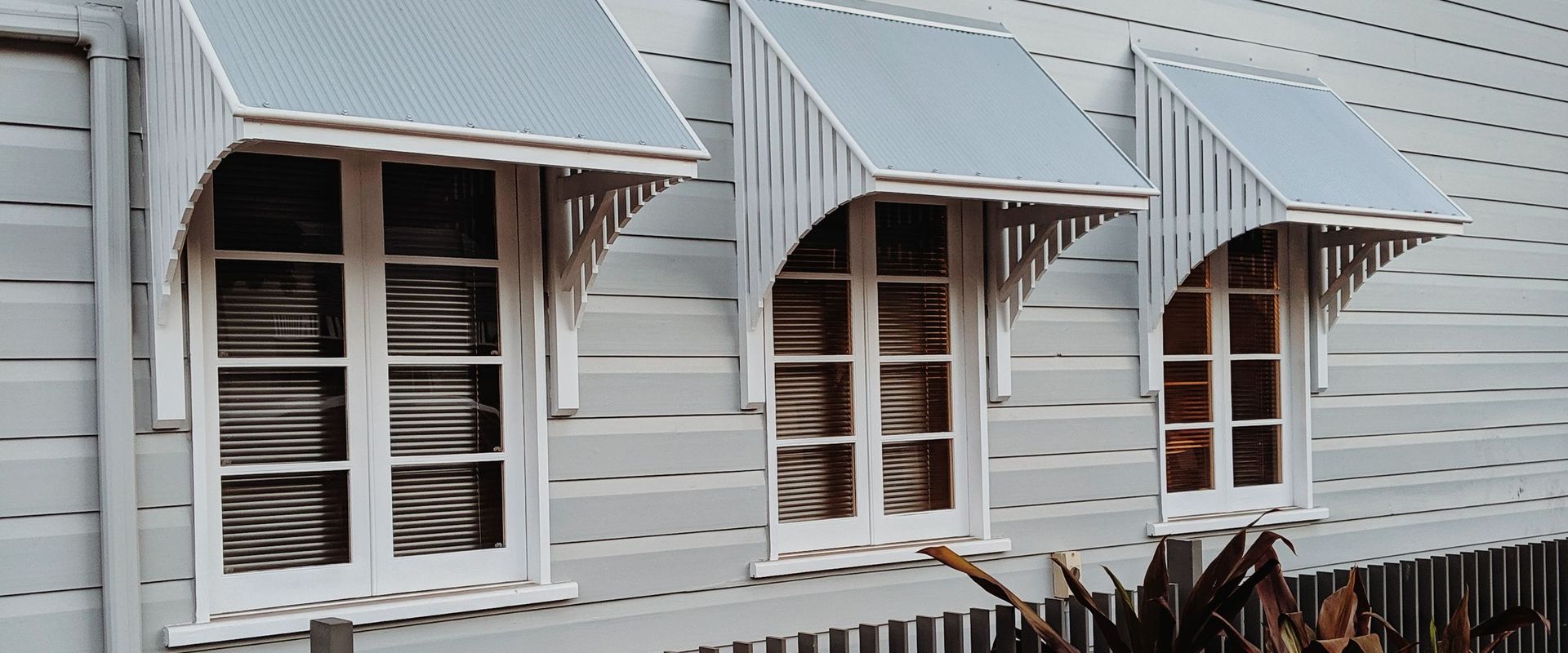 Weatherboard home with corrugated window awnings